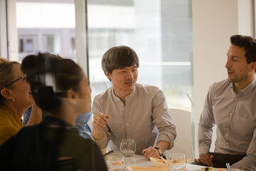 Business people eating sushi lunch in conference room