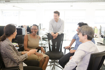 Business people meeting at computer in open plan office