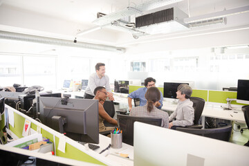 Business people meeting at computer in open plan office