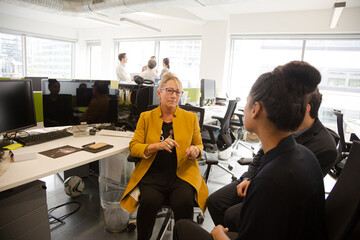 Business people talking in open plan office