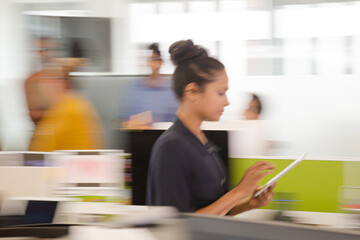 Businesswoman using tablet computer in open plan office © KOTO
