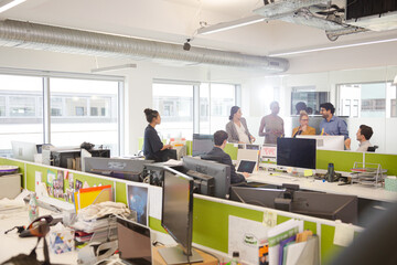 Business people talking in open plan office