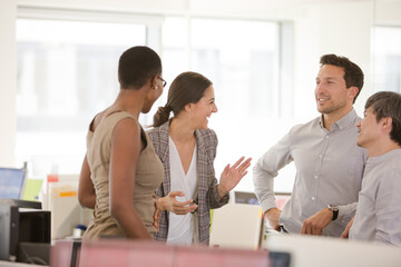 Business people talking in open plan office