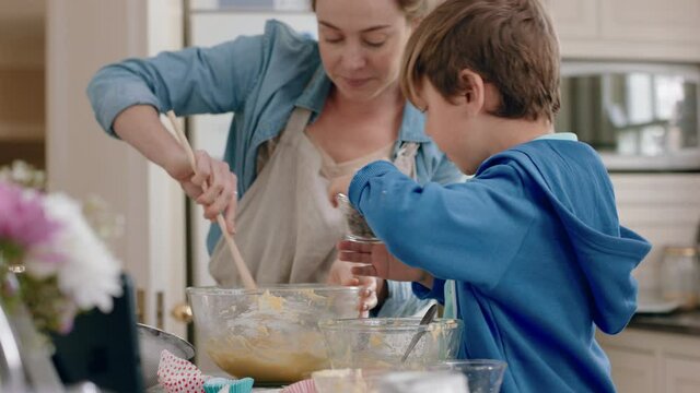 little boy helping mother bake in kitchen mixing ingredients baking cookies preparing recipe at home with mom teaching her son on weekend