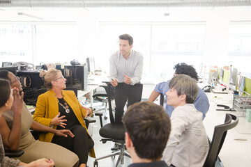 Business people meeting at computer in open plan office