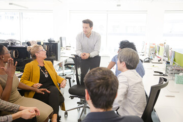 Business people meeting at computer in open plan office