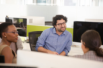 Business people meeting at computer in open plan office