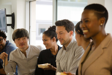 Obraz premium Happy business people enjoying sushi lunch