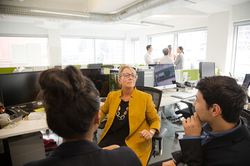 Business people talking in open plan office