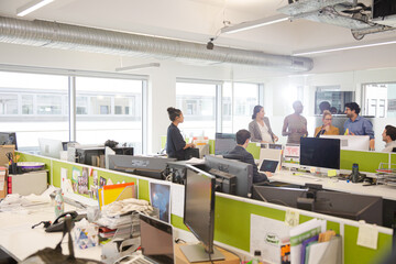 Business people talking in open plan office