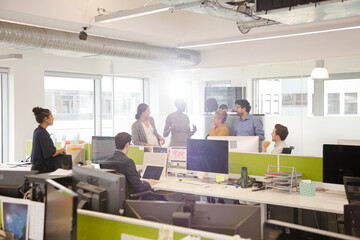 Business people talking in open plan office