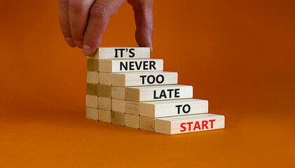 Success start symbol. Wooden blocks with words 'It is never too late to start'. Businessman hand....
