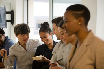 Obraz premium Happy business people enjoying sushi lunch