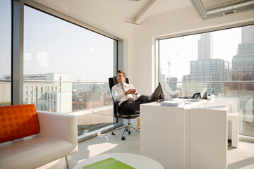 Businessman relaxing at desk in modern office