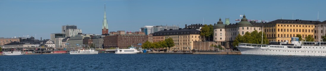 Fototapeta na wymiar The bay Riddarfjärden and the island Kungsholmen with the Town City Hall and the pier Norr Mälarstrand and Commuting boats a sunny day.