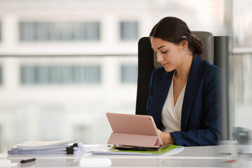 Businesswoman using smartphone and tablet computer at desk