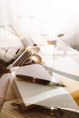 Justice and law concept.Male judge in a courtroom with the gavel, working with, computer and docking keyboard, eyeglasses, on table in morning light