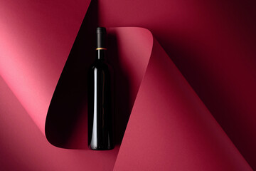 Bottle of red wine on a red background.