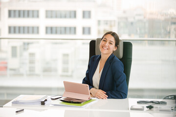 Businesswoman using smartphone and tablet computer at desk