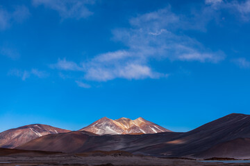 Mountain landscape in the Andes in the north of Chile with a volcano and clouds