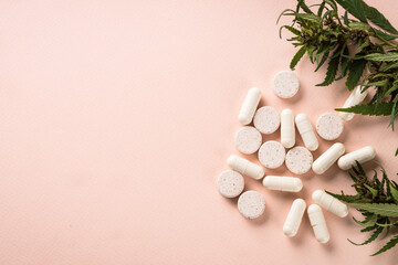 CBD pills and green leaves. Alternative medicine. Sedative, antibiotic, antioxidant using cannabis products. Flat lay.