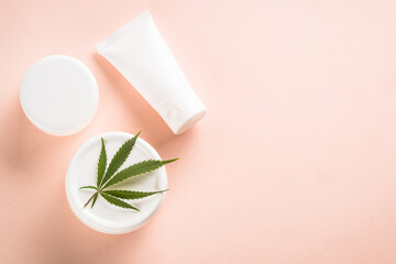 Cannabis cosmetic products. Natural cosmetic. Flat lay image on pink background.
