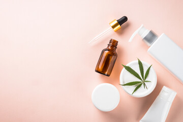 Cannabis cosmetic products. Natural cosmetic. Cream, soap, serum and others. Flat lay image on pink background.