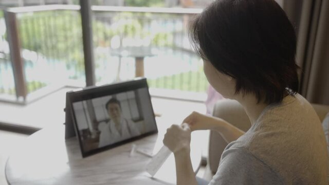 Close up scene from behind of people have online consultation with doctor to self test antigen test kit from home. Medical Consult online service concept for SARS 2019-nCoV COVID-19 coronavirus.