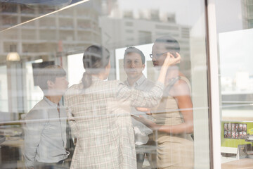 Business people talking in open plan office