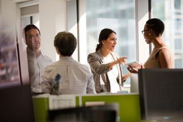 Business people talking in open plan office