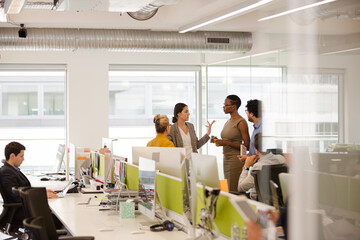 Business people talking in open plan office