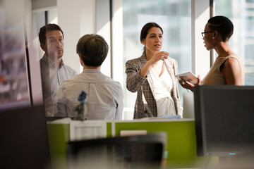 Business people talking in open plan office