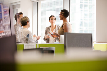 Business people talking in open plan office