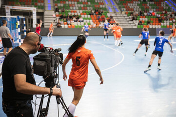 TV camera and cameraman during handball match - obrazy, fototapety, plakaty