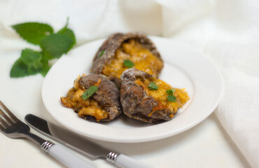 Stuffed Parasol Mushroom with cheese and herbs on white plate
