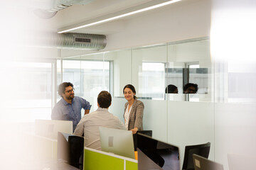 Business people talking in open plan office