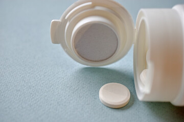 White flat medicine tablets on a blue background