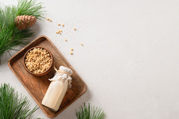 Obraz na płótnie Canvas Healthy cedar nut milk on white background. Healthy vegetarian drink. Top view. Copy space. Alternative milk replacer.