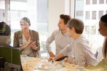 Business people enjoying sushi lunch in conference room