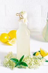 Obraz na płótnie Canvas Bottle of homemade healthy organic elderflower cordial juice lemonade with fresh elderflowers and fresh ingredients for healthy and refreshing drink .