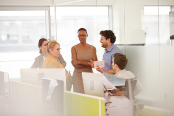 Business people talking in open plan office