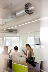 Business people talking in open plan office