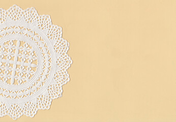 Part of a paper Cup Cake Doily on top of a yellow paper. With empty space  - obrazy, fototapety, plakaty