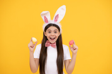 surprised easter kid girl in bunny ears and bow tie hold painted eggs, easter