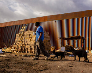 Fotografía hecha en la frontera de Mexicali B.C. México.
Hombre acompañado de sus perros, cuida...