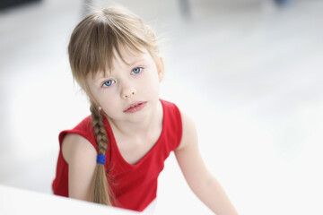 Portrait of sad little girl in red dress