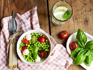 Salad vegetarian. Fresh vegetable salad with tomato, cucumber, basil, green peas, mozzarella cheese.