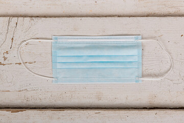 Surgical mask lying on a wooden table