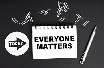 On a black background, a round plate - Today and a notebook with the inscription - Everyone Matters