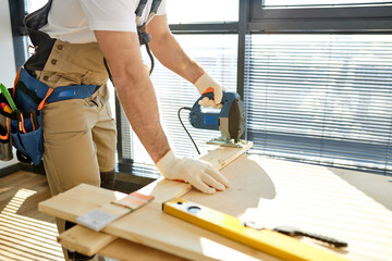 Close-up Carpenter Working On Wood With Electric Jigsaw In New House. Joinery Work On The Production And Renovation Of Wooden Furniture. Small Business Concept